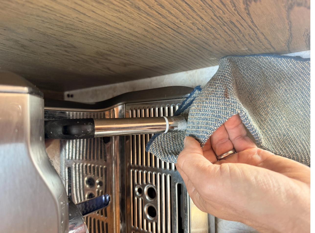 Wiping the steam wand clean after use